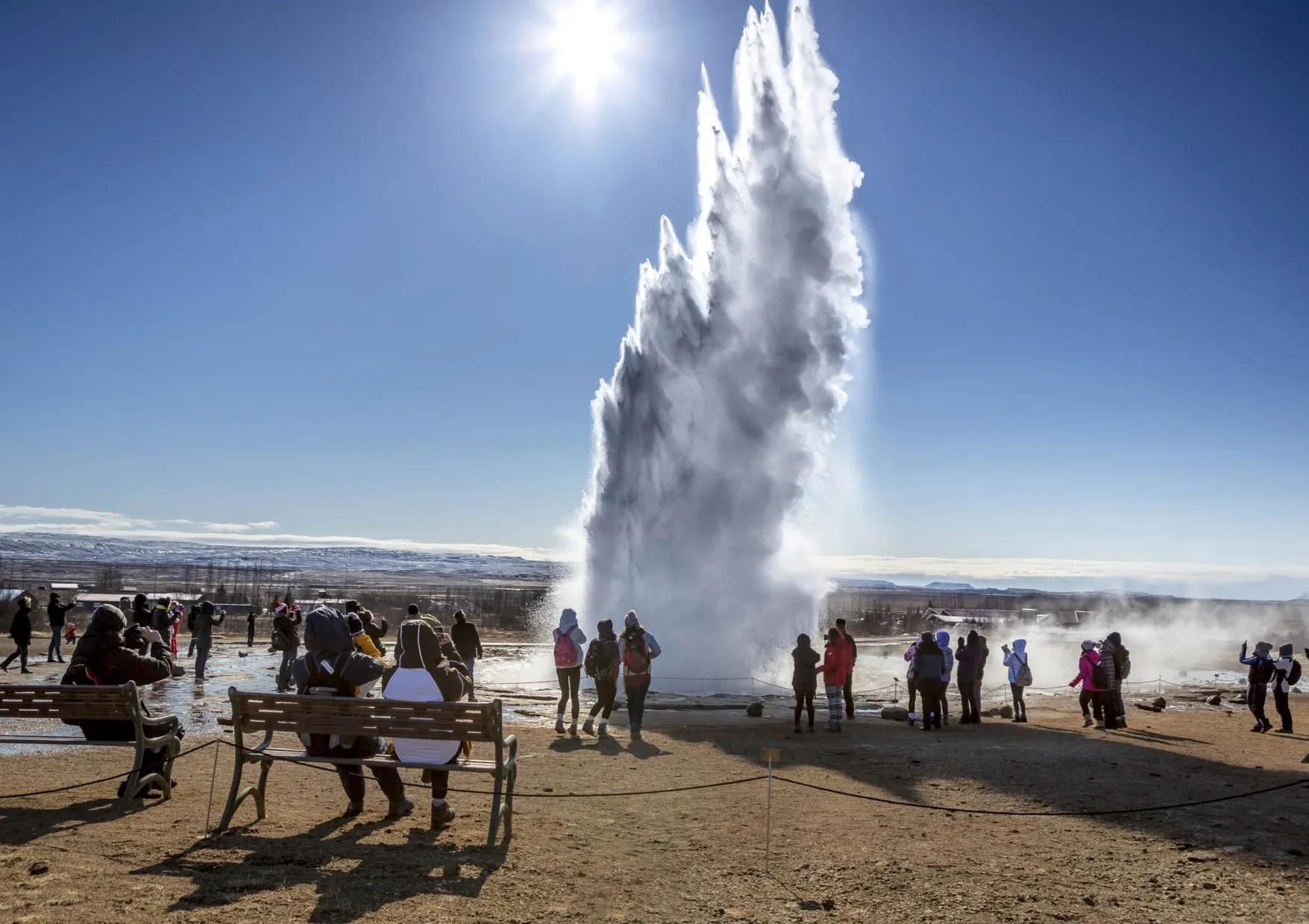 Menschengruppe bestaunt Geysir in Island